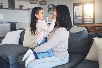 Touch, happy and playful with mother and daughter on sofa for love, care and support. Funny, calm and relax with woman and young girl embrace in living room of family home for peace, cute and bonding