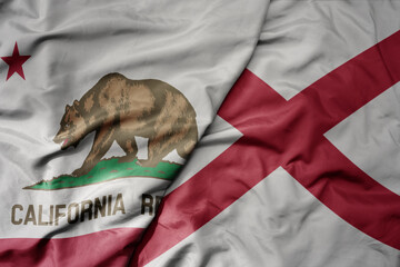 big waving colorful national flag of alabama state and flag of california state .