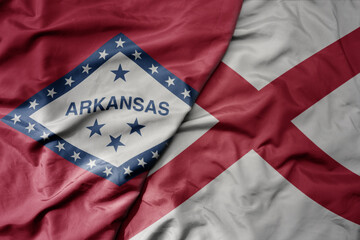 big waving colorful national flag of alabama state and flag of arkansas state .