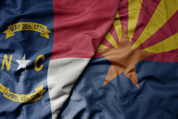 big waving colorful national flag of arizona state and flag of north carolina state .