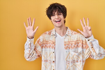 Young man wearing casual summer shirt showing and pointing up with fingers number nine while...