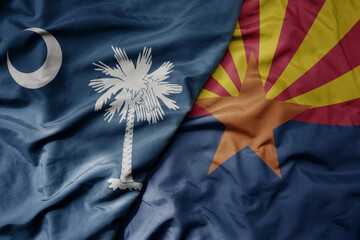 big waving colorful national flag of arizona state and flag of south carolina state .
