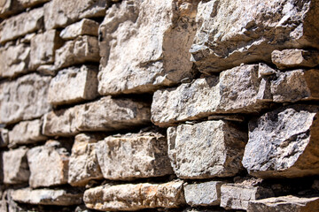 Stone antique old wall as a background or texture. Vintage background of a fortress wall in loft and grunge style with place for text and copy space.