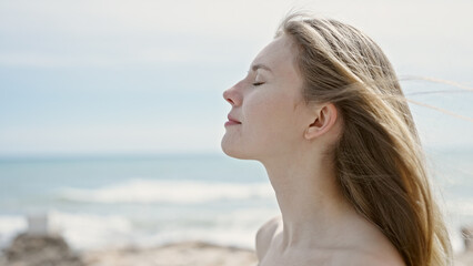 Young blonde woman tourist breathing at beach