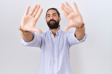 Hispanic man with beard wearing casual shirt doing frame using hands palms and fingers, camera perspective