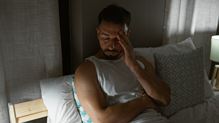 Fototapeta premium Young arab man stressed sitting on bed at bedroom