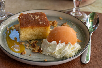 Piece of homemade orange cake with melon ice cream and whipped cream