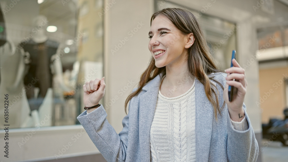 Sticker Young hispanic woman dancing using smartphone at street