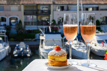 Summer party, drinking of French brut rose champagne sparkling wine in glasses in yacht harbour of...