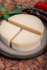 Italian cheese, Provolone dolce cow cheese from Cremona served with olive bread and tomatoes close up