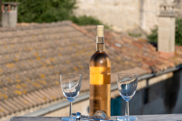 French cold rose dry wine from Provence in two glasses in sunny day with view on old roofs of Arles...