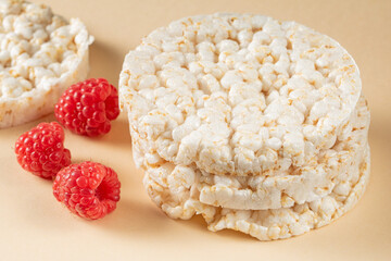 A stack of rice cakes with raspberries scattered around