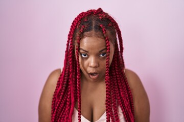 African american woman with braided hair standing over pink background afraid and shocked with surprise and amazed expression, fear and excited face.