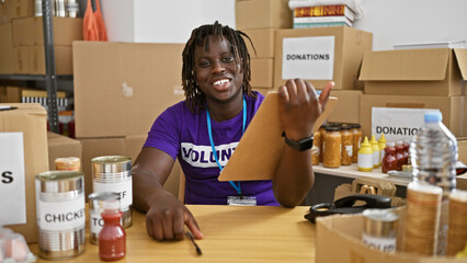 African american man volunteer smiling confident holding clipboard at charity center