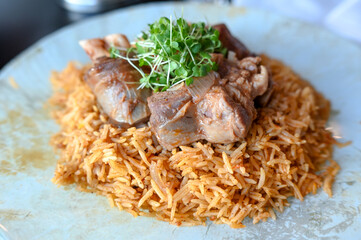 Lamb meat and rice served on a plate in a restaurant. 