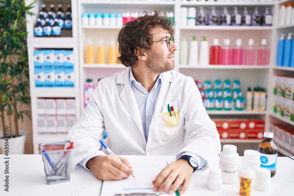 Sticker hispanic young man working at pharmacy drugstore looking to side, relax profile pose with natural fa