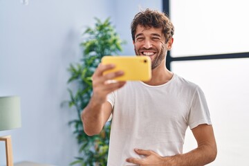 Young man smiling confident watching video on smartphone at home