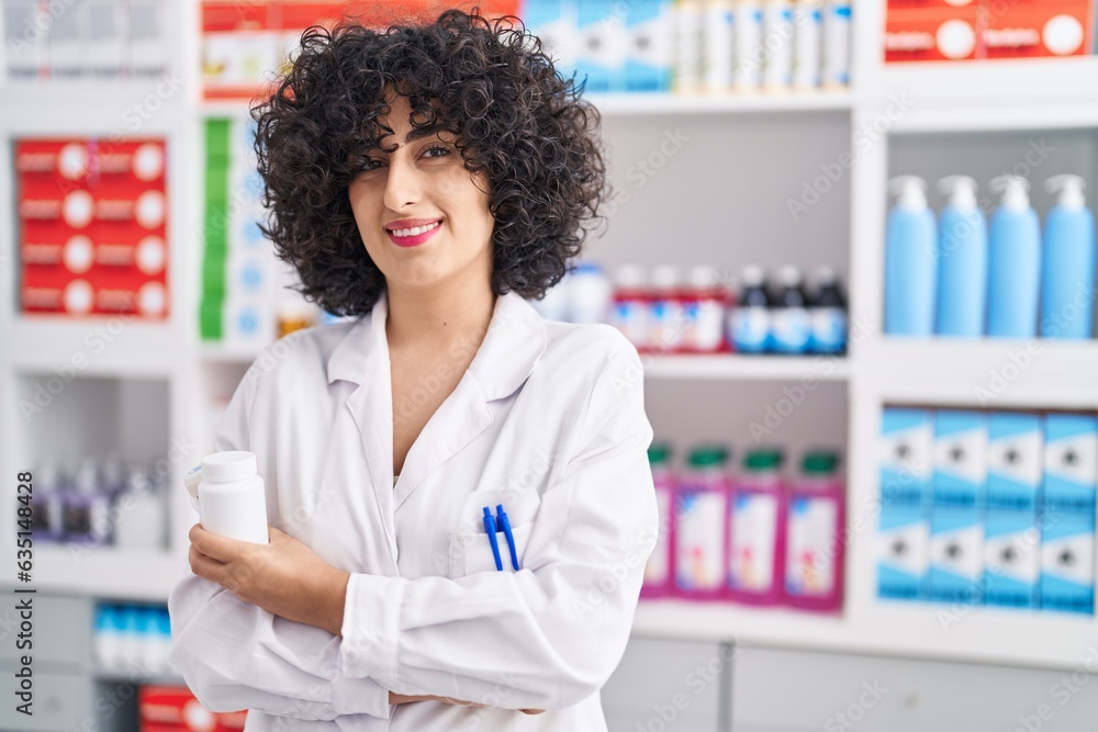 Canvas Prints young middle east woman pharmacist standing with arms crossed gesture at pharmacy