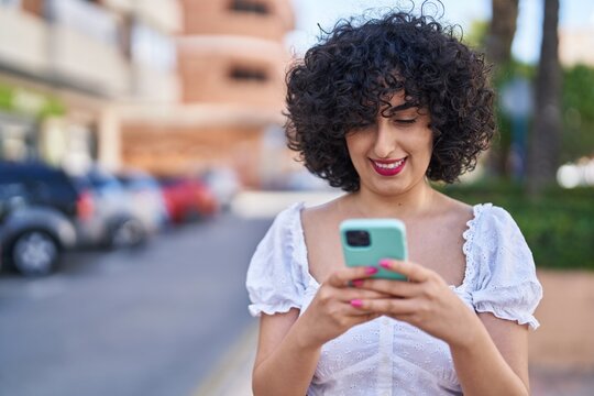 Young middle east woman smiling confident using smartphone at park