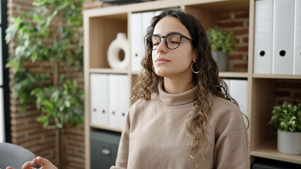 Young beautiful hispanic woman business worker doing yoga exercise breathing at office