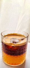 Coffee combined with fresh orange juice in transparent glass served with ice, home made recipe