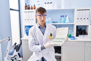 Caucasian man working at scientist laboratory depressed and worry for distress, crying angry and...