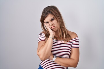 Young hispanic woman standing over isolated background thinking looking tired and bored with depression problems with crossed arms.