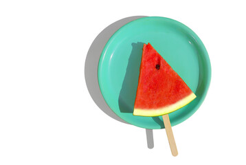 Watermelon slice with wooden stick on green plate isolated for healthy food concept.