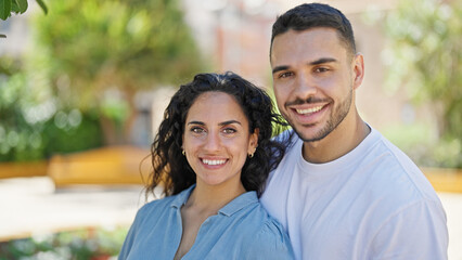 Obraz premium Man and woman couple smiling confident standing together at park