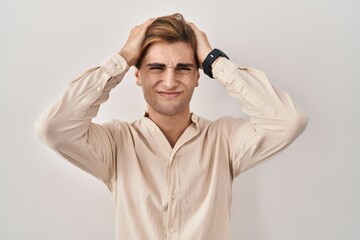 Young man standing over isolated background suffering from headache desperate and stressed because pain and migraine. hands on head.
