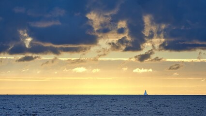 Colorful cloudy sky at sunset. Gradient color. Sky texture, abstract nature background. Yacht on the horizon.