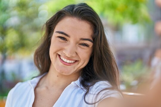 Young hispanic woman smiling confident making selfie by the camera at park