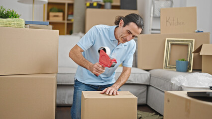 Middle age man packing cardboard box at new home