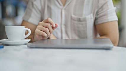 Young hispanic man sitting on bed being sick at coffee shop terrace