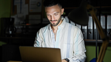 Fototapeta premium Young hispanic man business worker using laptop at the office