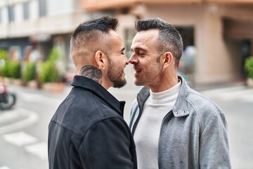 Two men couple smiling confident standing together at street