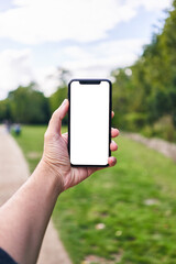 Man holding smartphone showing white blank screen at park