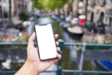 Man holding smartphone showing white blank screen at amsterdam