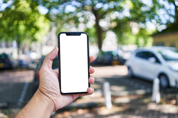 Man holding smartphone showing white blank screen at street