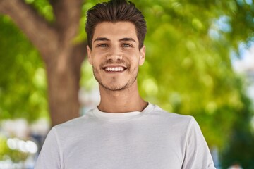 Young hispanic man smiling confident standing at park