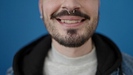 Young hispanic man smiling confident over isolated blue background