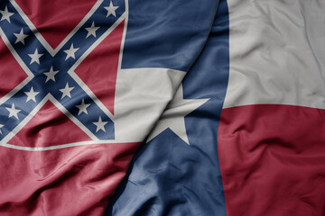 big waving colorful national flag of texas state and flag of mississippi state .