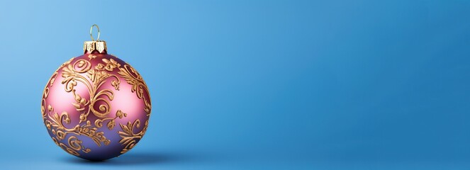 red Christmas Bauble  decorated with pattern hanging on a ribbon on a blue background,.