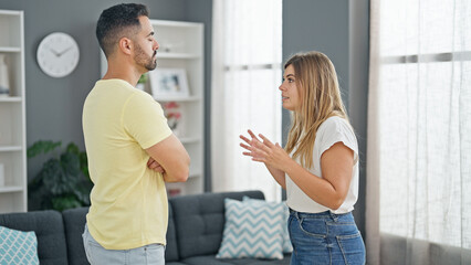 Man and woman couple standing together arguing at home