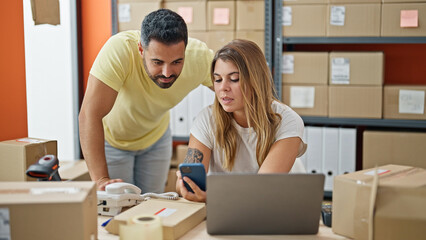 Man and woman ecommerce business workers using smartphone at office