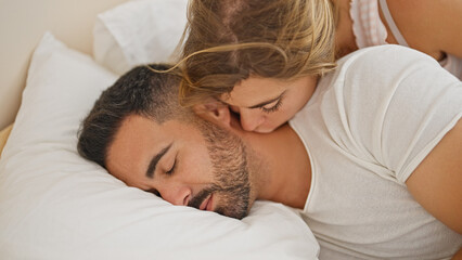 Man and woman couple lying on bed kissing while sleeping at bedroom