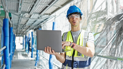 Young hispanic man architect using laptop working at construction place