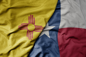 big waving colorful national flag of texas state and flag of new mexico state .