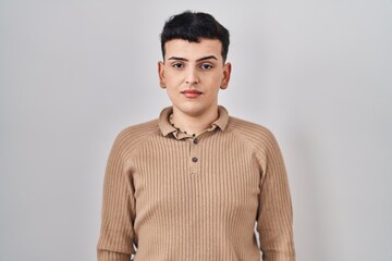 Obraz premium Non binary person standing over isolated background relaxed with serious expression on face. simple and natural looking at the camera.