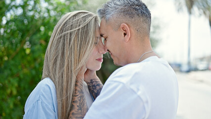 Fototapeta premium Man and woman couple looking each other with lovely expression at park